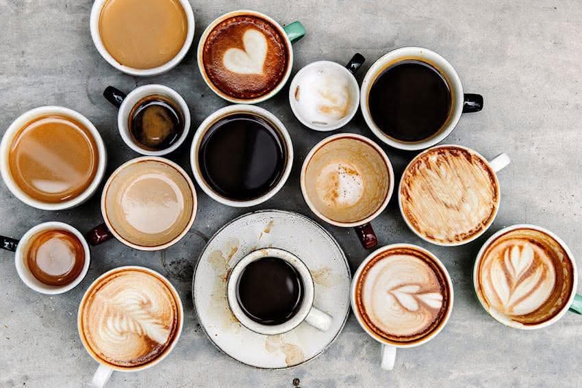 An overhead flatlay of many different coffee drinks and lattes.
