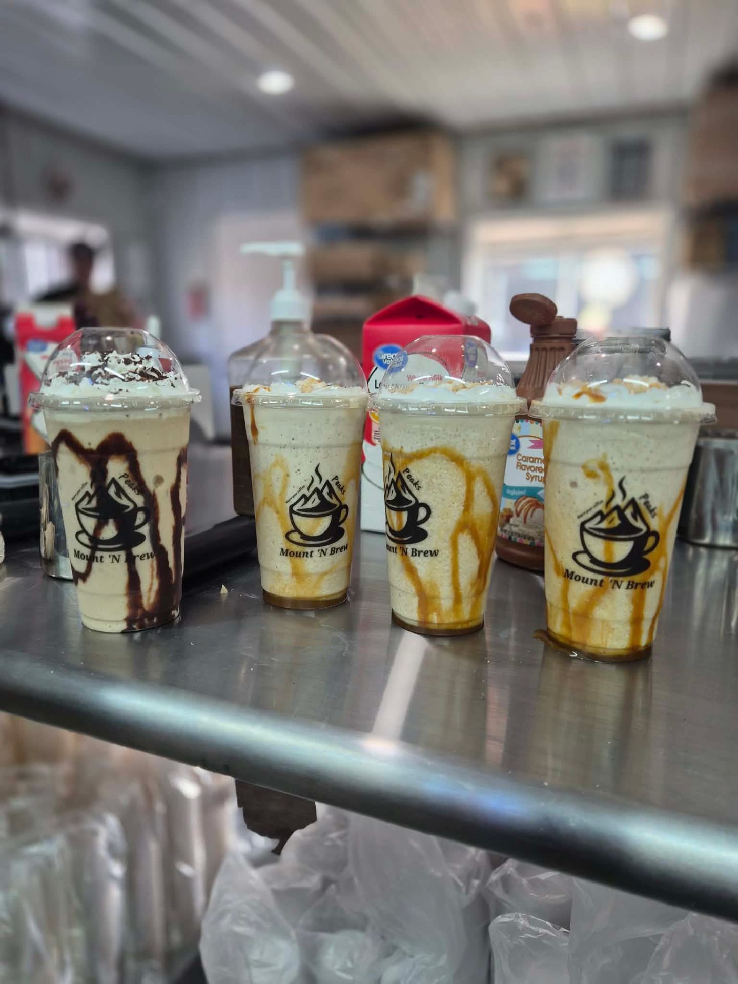 A lineup of four Mount 'N Brew branded frozen brews with chocolate and caramel drizzle.