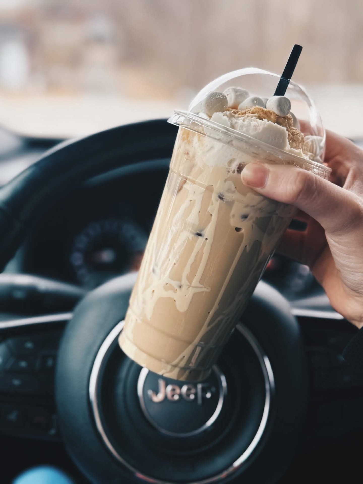 A s'mores iced coffee topped with toasted marshmallows and graham crumbs.